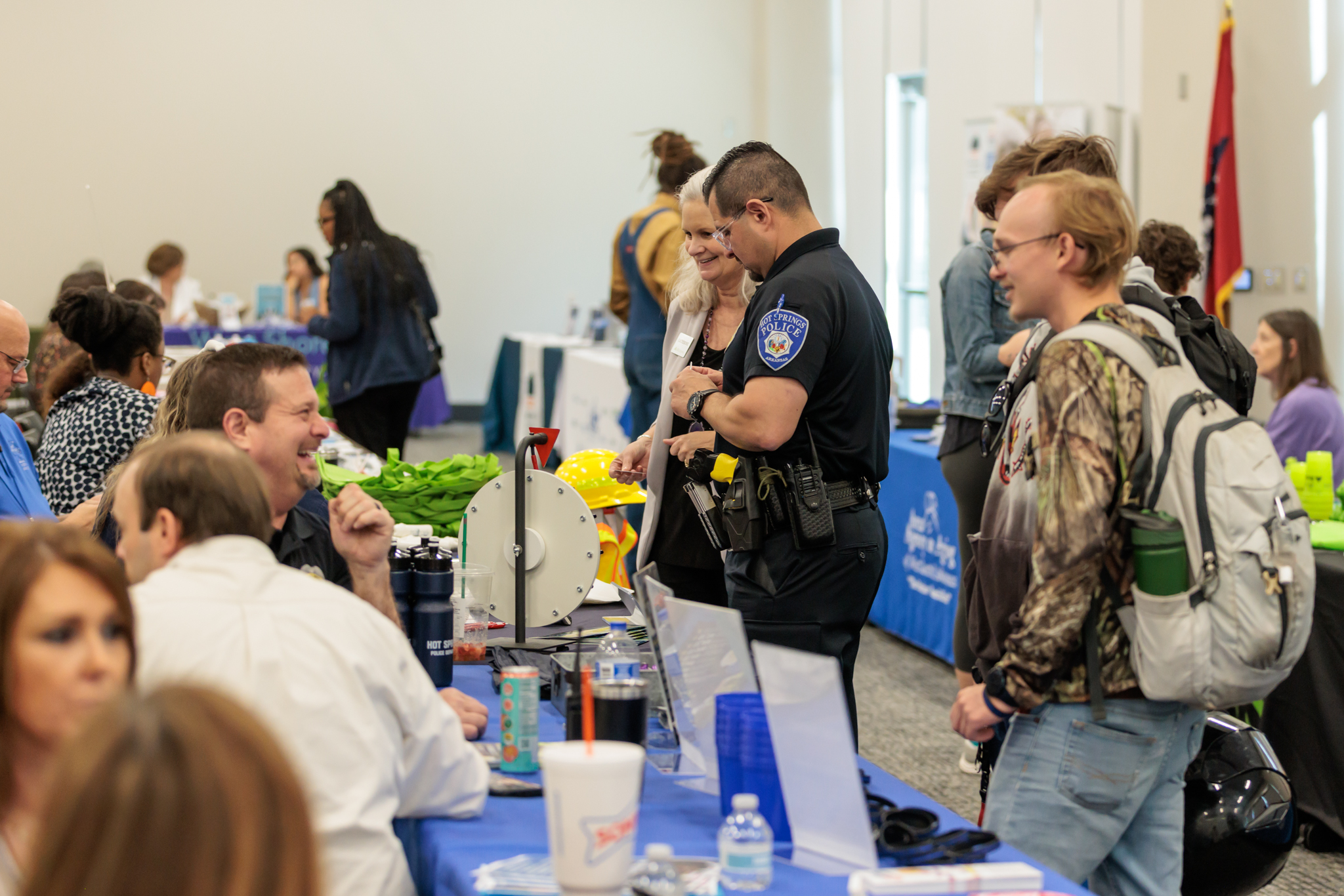 People standing in room visiting tables of different employers.