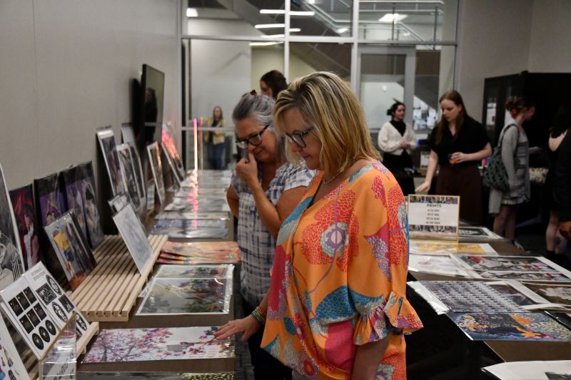 People looking at student created art pieces.