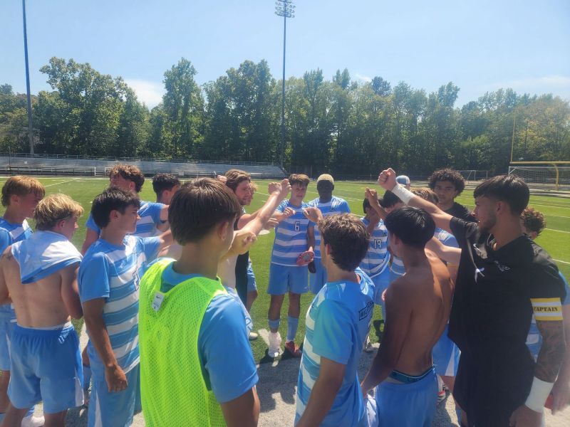 Men's soccer team celebrating after win.